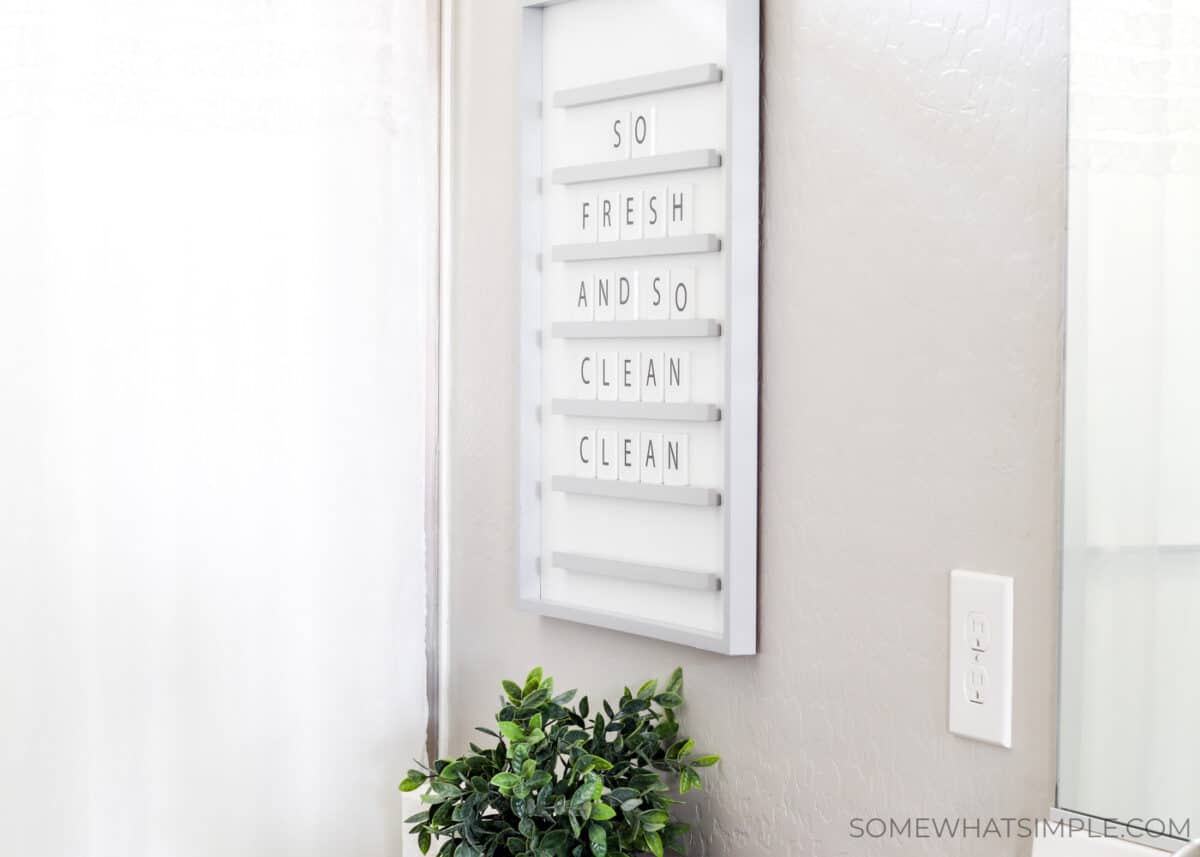 a letter board hanging on the wall above a toilet that reads, so fresh and so clean clean