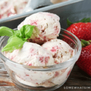 bowl of homemade strawberry ice cream net to strawberries