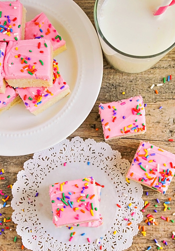 looking down on a plate of the best ever sugar cookies with a couple others on a table next to a glass of milk