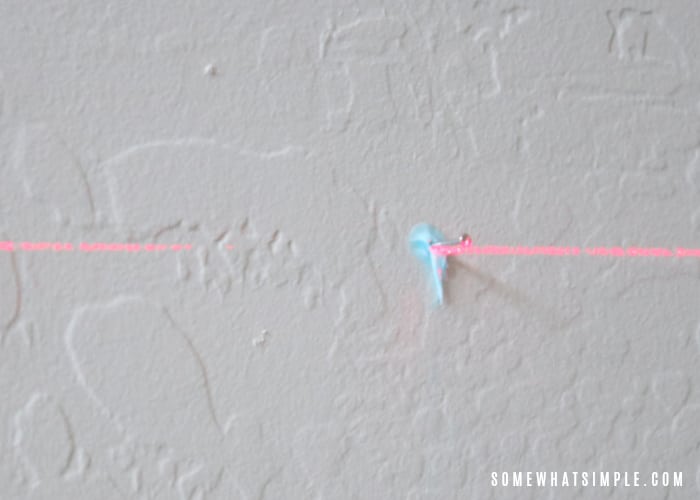 a laser level beam and a nail on a wall