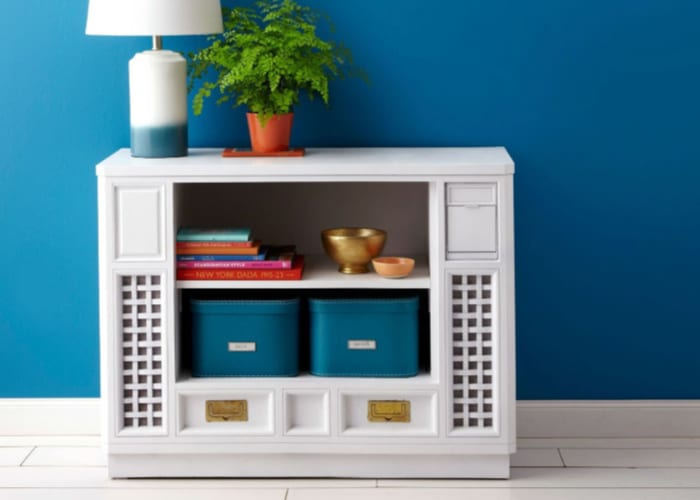 an upcycled tv cabinet turned into a shelf with baskets