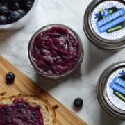 a jar of blueberry honey butter next to two more jars