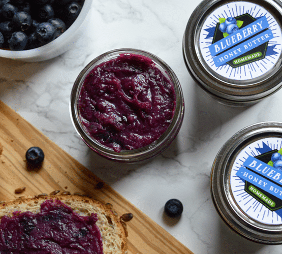 a jar of blueberry honey butter next to two more jars