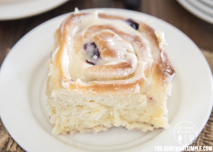 a homemade blueberry cinnamon roll on a white plate