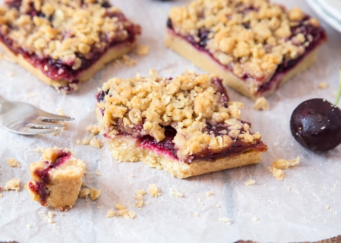 squares of Cherry Streusel Bars on a baking sheet