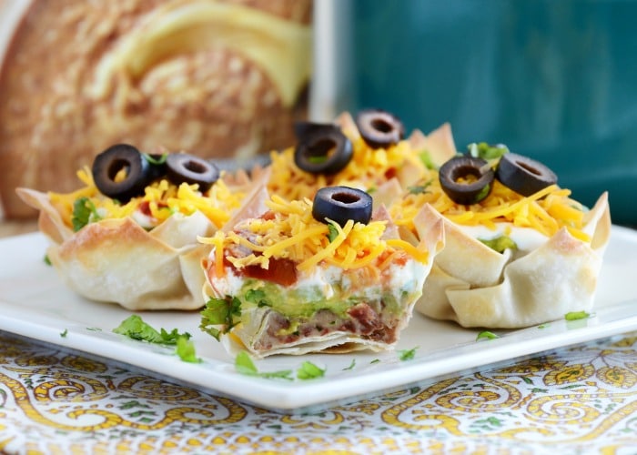 seven layer dip cups on a plate