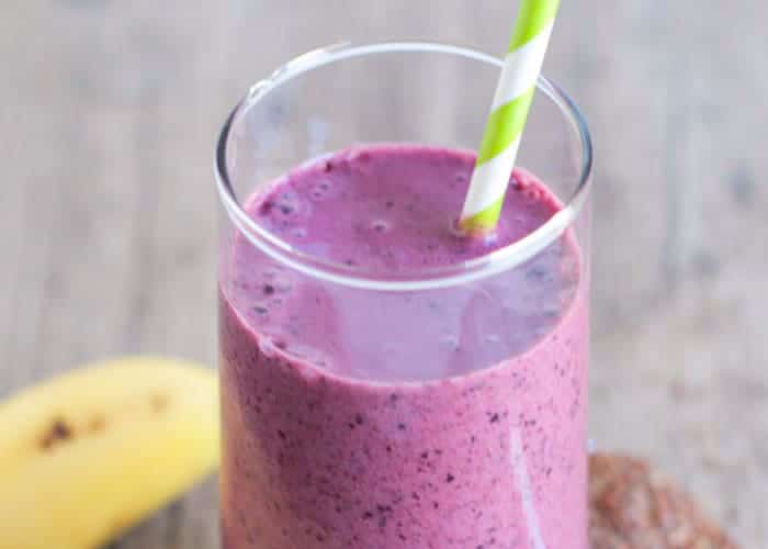 a glass filled with a blueberry pomegranate smoothie