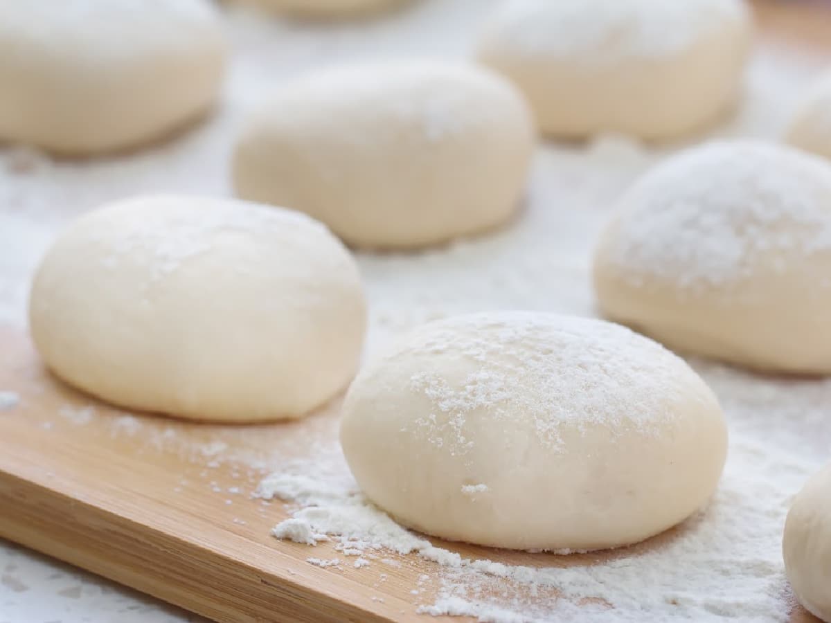 homemade pizza dough on a wood cutting board