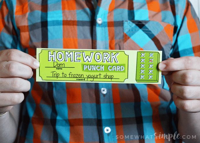 a boy holding a green Homework printable punch card