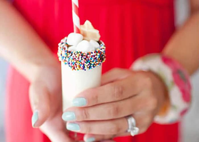 someone holding a milkshake shooter mocktail drink