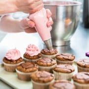 cupcake baking tips with woman frosting chocolate cupcakes with pink frosting