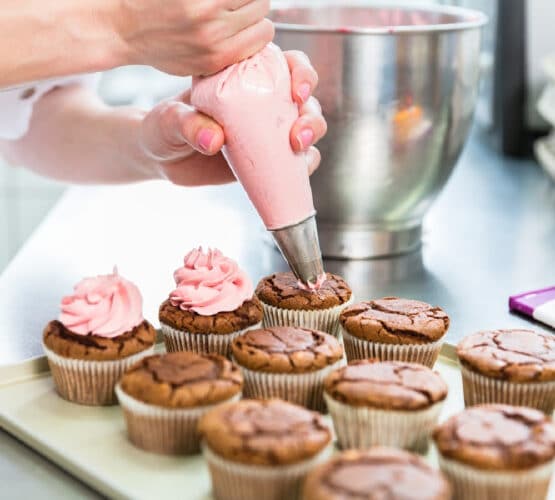 cupcake baking tips with woman frosting chocolate cupcakes with pink frosting