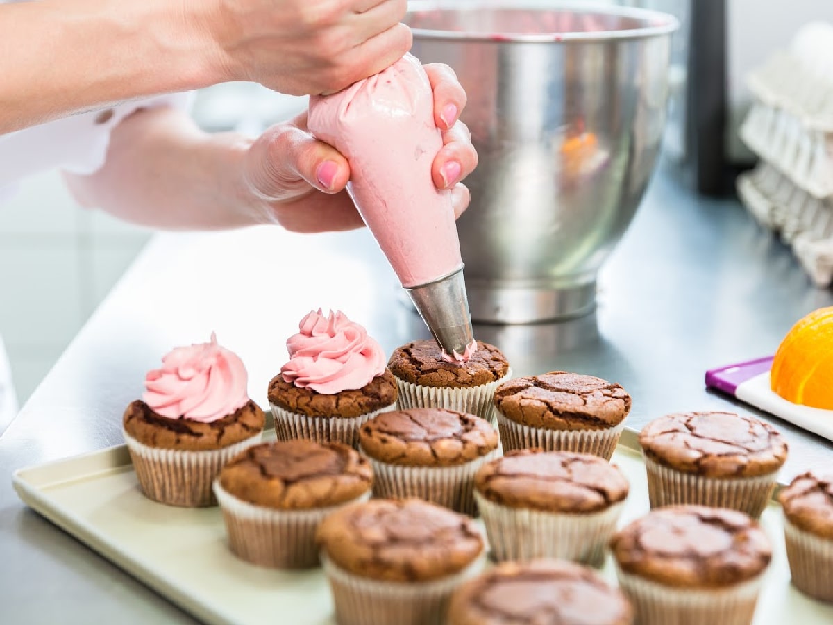 cupcake baking tips with woman frosting chocolate cupcakes with pink frosting