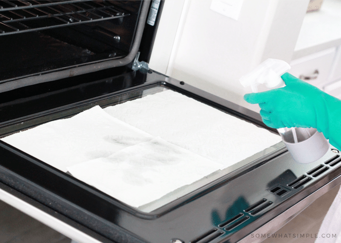 spraying an ammonia mixture onto a glass oven door