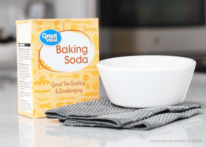 a box of baking soda and a white bowl used to make oven glass cleaner