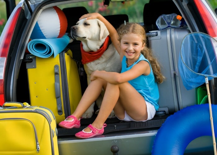 a girl in the back of a car with her dog