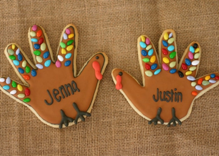 two handprint turkey cookies with brightly colored decorations