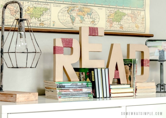 yarn wrapped letters on a book shelf that spell out the word read