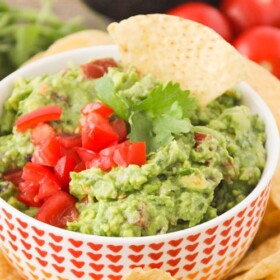 a bowl of Zesty Guacamole next to a pile of tortilla chips