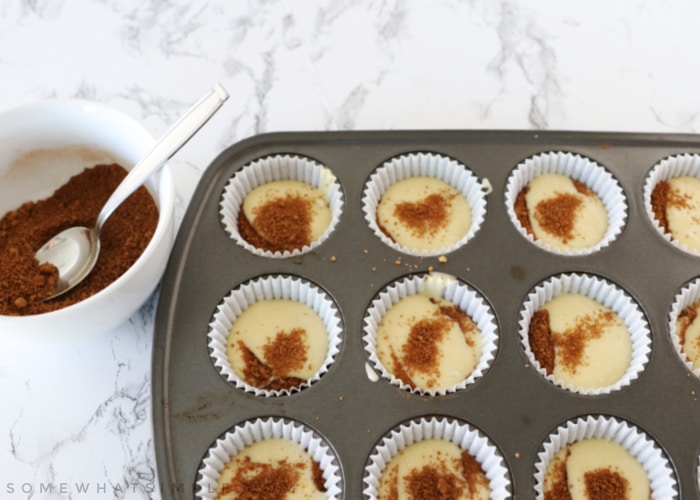 layering cinnamon roll cupcakes with batter and cinnamon mixture