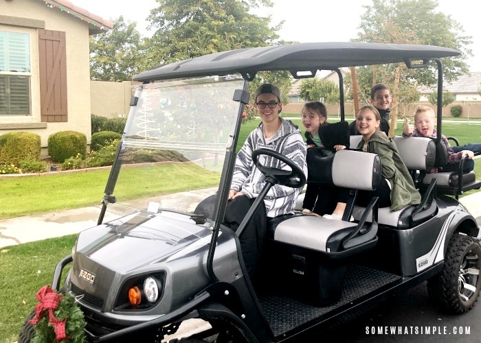 Kids on a golf cart looking at Christmas lights