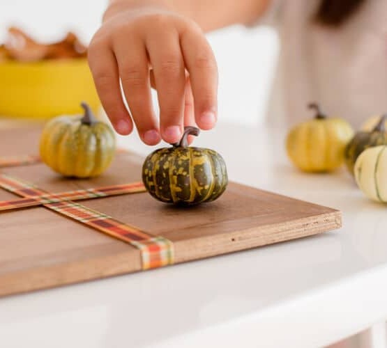 Thanksgiving Activities - A Child playing Tic Tac Toe with Pumpkins