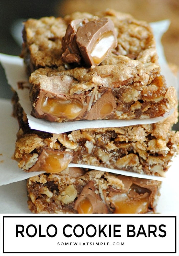 a stack of cookie bars made with rolos separated by parchment paper
