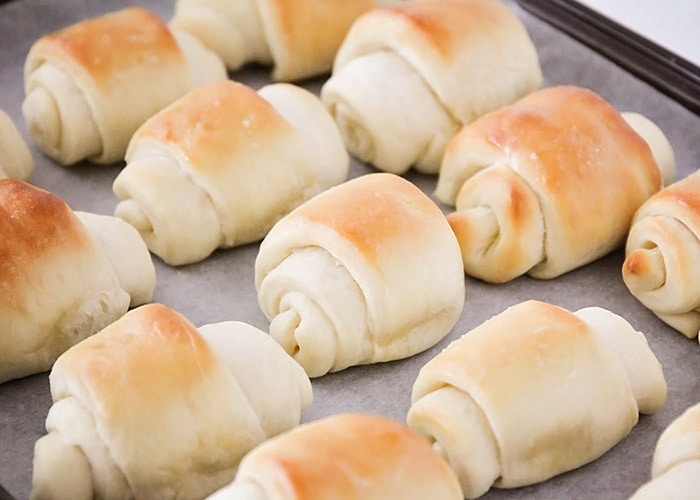 a tray of baked lion house rolls