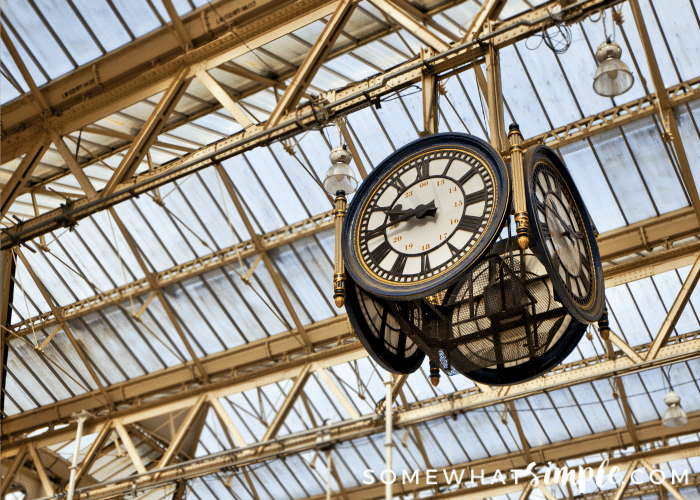 a clock hanging from St Pancras Station in London, England