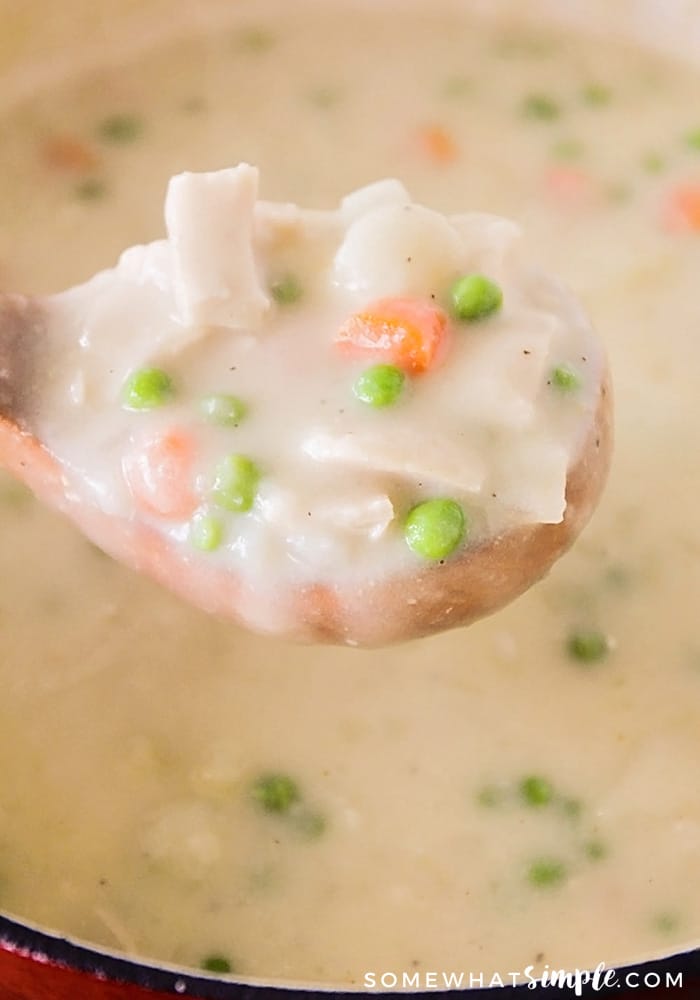 a wooden spoon holding a scoop of creamy soup