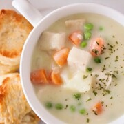 looking down on a bowl of chicken pot pie soup and biscuits