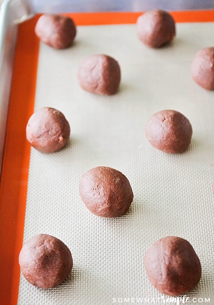 round balls of chocolate sugar cookie dough on a baking sheet