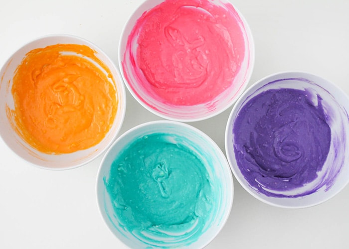 small bowls with different colored frosting 