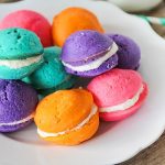 a plate full of pastel colored mini whoopie pies