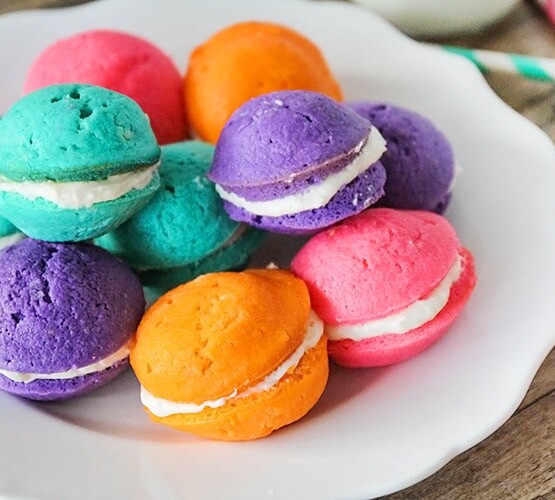 a plate full of pastel colored mini whoopie pies