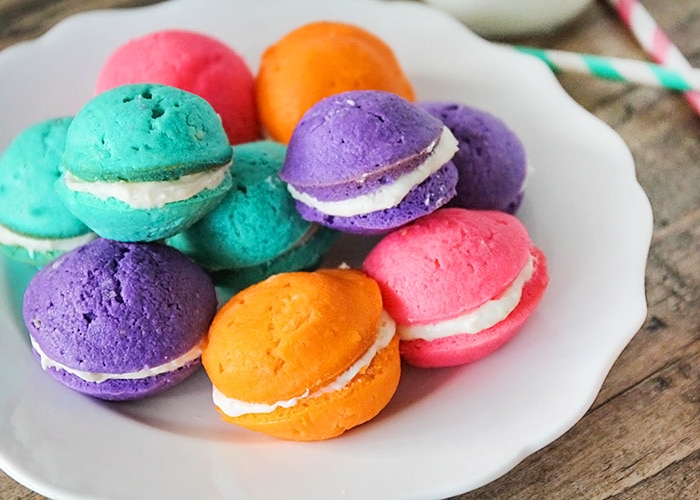 a plate full of pastel colored mini whoopie pies