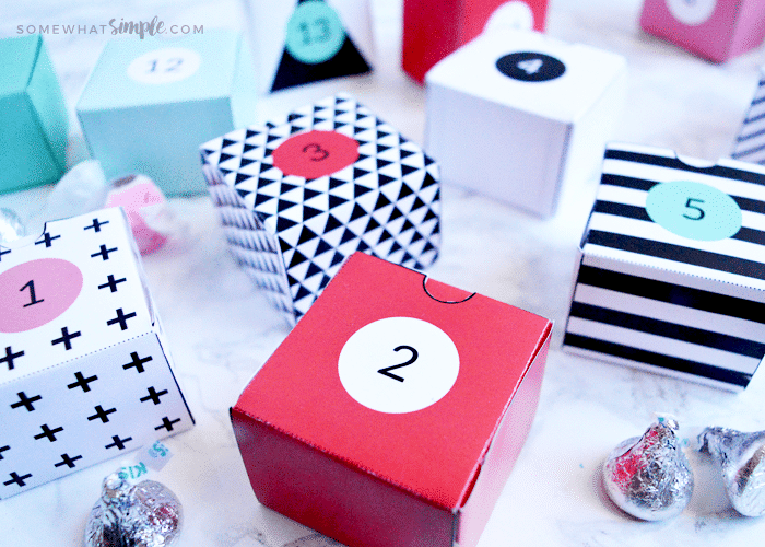 red, white, black and pink paper boxes with numbers on them sitting on a counter