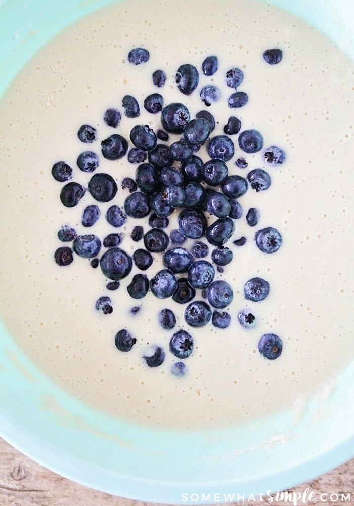 a bowl of pancake batter with fresh blueberries