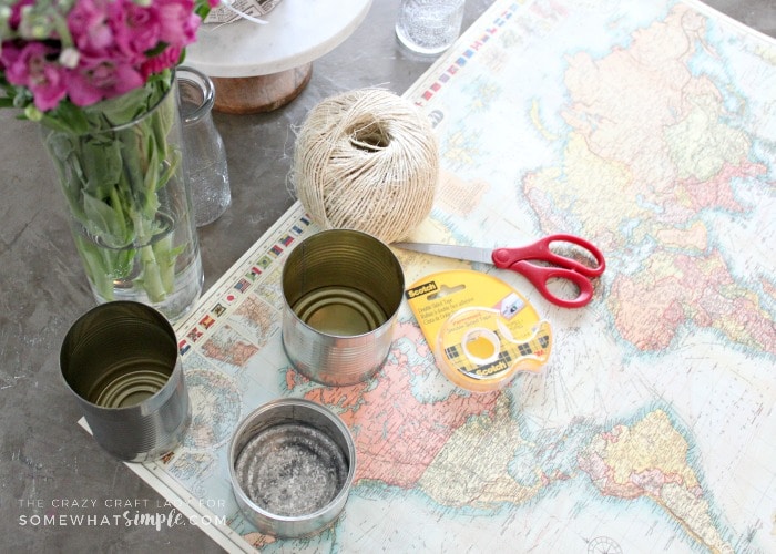 Make an upcycled Tin Can Vase for fresh flowers. Recycle and repurpose empty tin cans by covering them with map paper for a fun and unique vase.