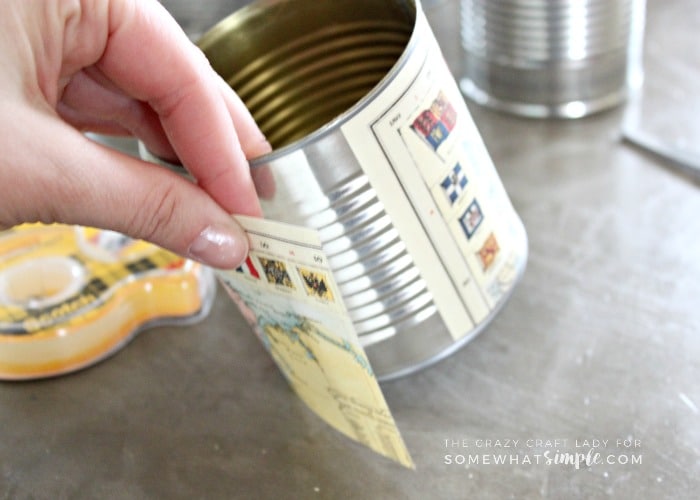 Make an upcycled Tin Can Vase for fresh flowers. Recycle and repurpose empty tin cans by covering them with map paper for a fun and unique vase.