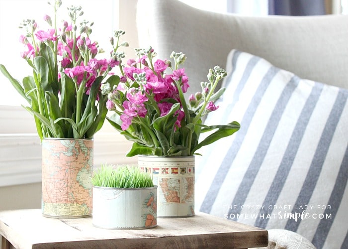 Make an upcycled Tin Can Vase for fresh flowers. Recycle and repurpose empty tin cans by covering them with map paper for a fun and unique vase.