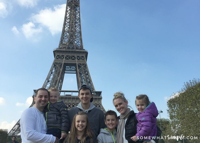 A family of seven standing in front of the Eiffel town on their European Vacation