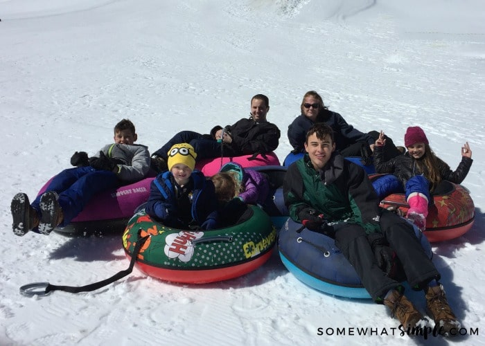 a family playing in the snow with innertubes