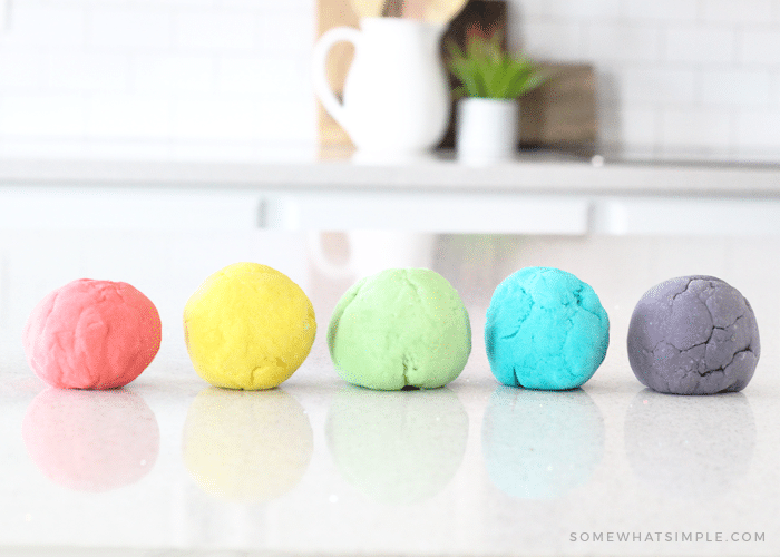 five different colored balls of homemade playdough sitting on a counter that were made with this easy recipe