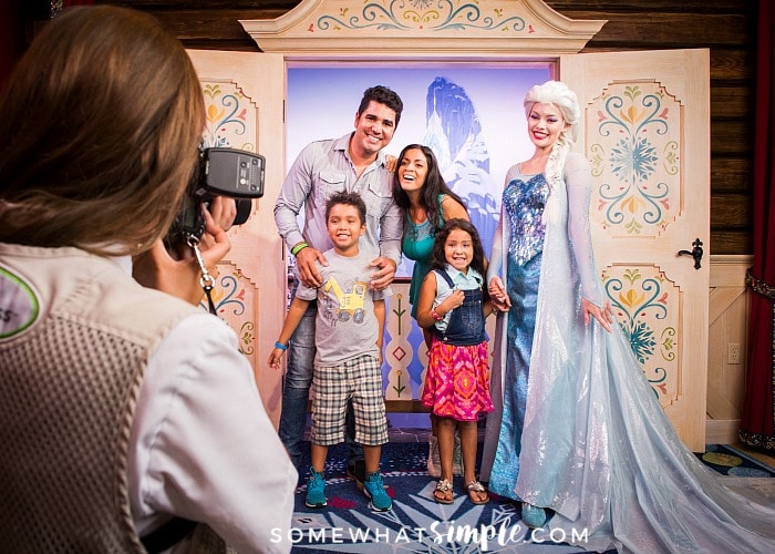 a family getting their picture taken with Elsa from the movie Frozen at the Magic Kingdom