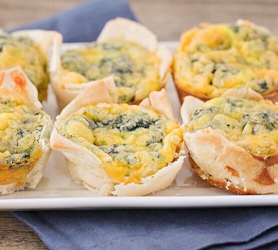 white plate with mini quiches in 2 rows