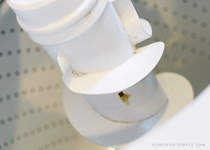 a close up look of an agitator inside a washing machine that has dirt and grime all over it.