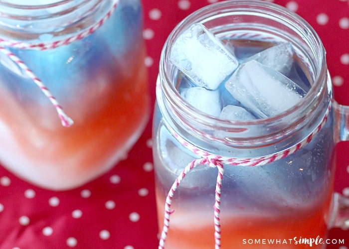 looking down on two Mason jar glasses filled with a layered red white and blue 4th of july drink