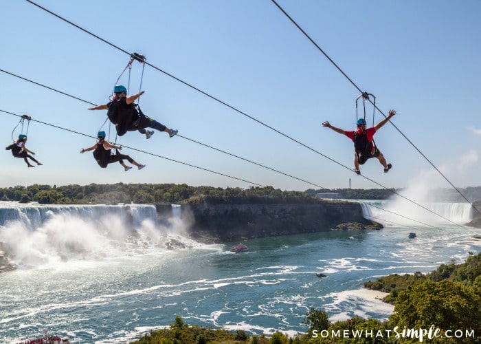 people zipling next to niagara falls