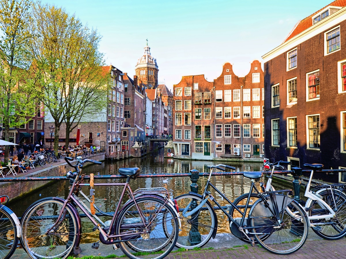 bikes locked up on a bridge over a canal in amsterdam